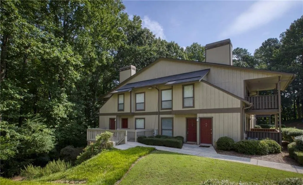 View of front of property with a chimney, a balcony, and a front lawn View of front of property with a chimney, a balcony, and a front lawn
