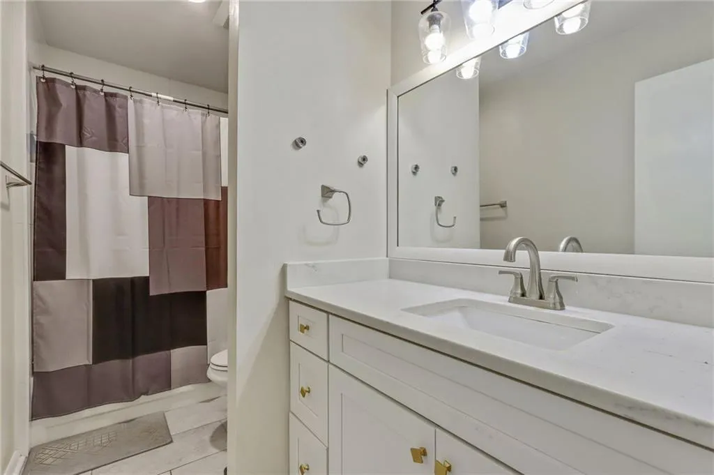 Bathroom with vanity, a shower with shower curtain, and light tile patterned floors Bathroom with vanity, a shower with shower curtain, and light tile patterned floors