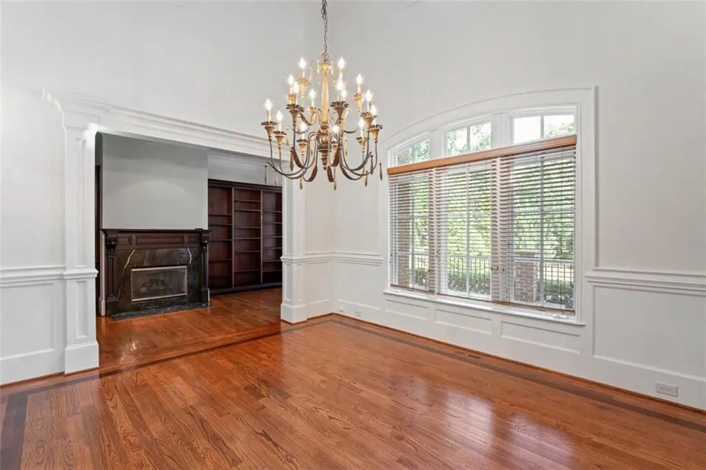 Spare room featuring dark hardwood / wood-style flooring and a notable chandelier