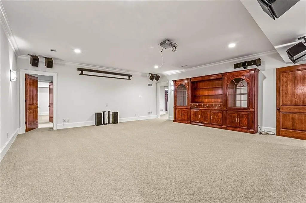 Carpeted home theater with ornamental molding