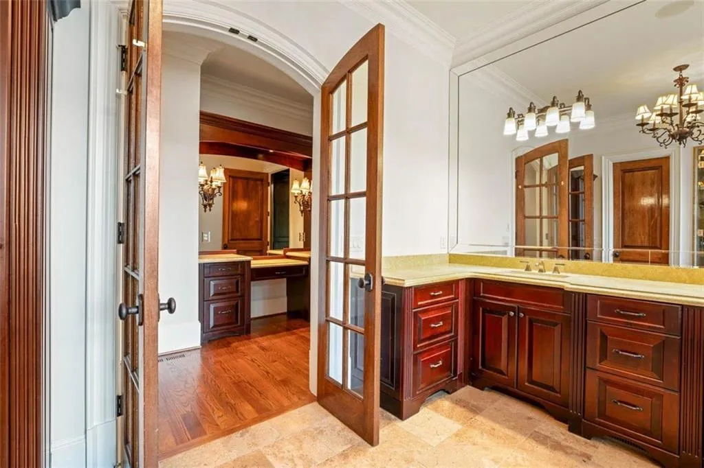 Bathroom featuring crown molding, french doors, vanity, a chandelier, and tile floors