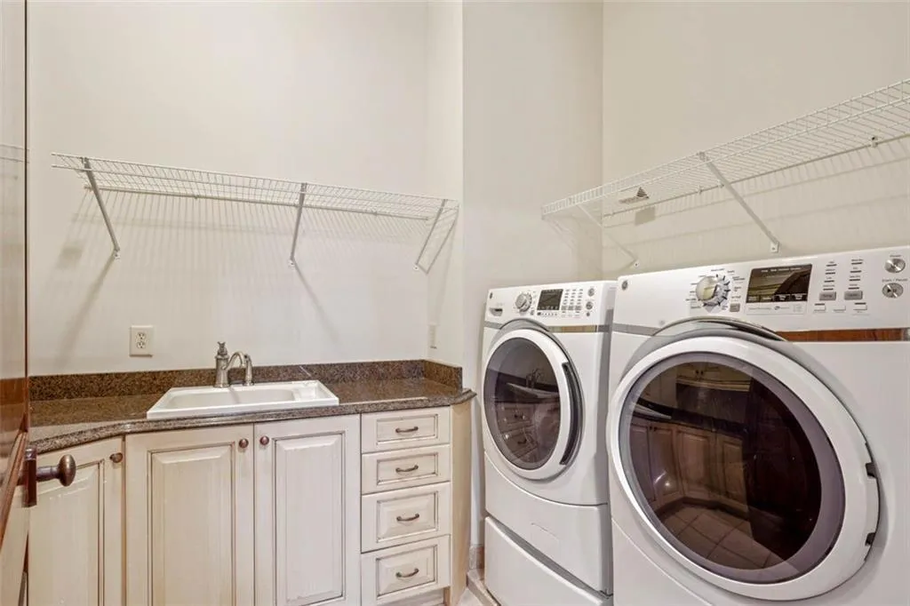 Laundry room with washer and dryer, sink, and cabinets