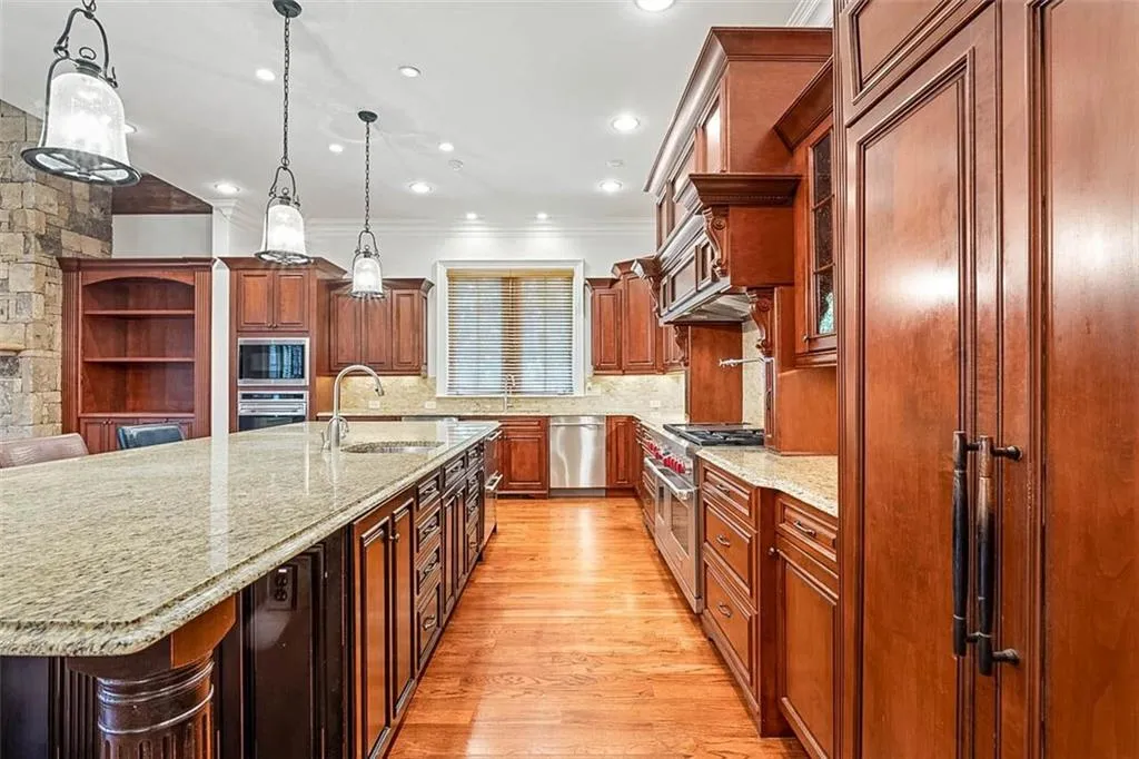 Kitchen featuring light wood-type flooring, a breakfast bar, sink, and built in appliances
