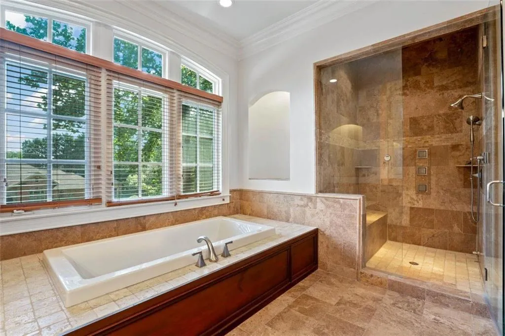 Bathroom featuring ornamental molding, tile flooring, and separate shower and tub