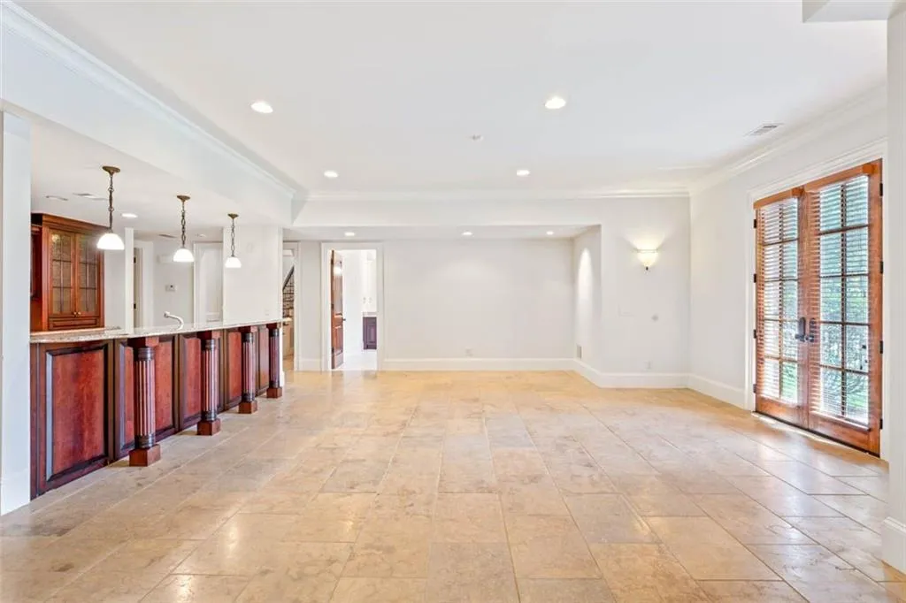 Tiled empty room with french doors and ornamental molding