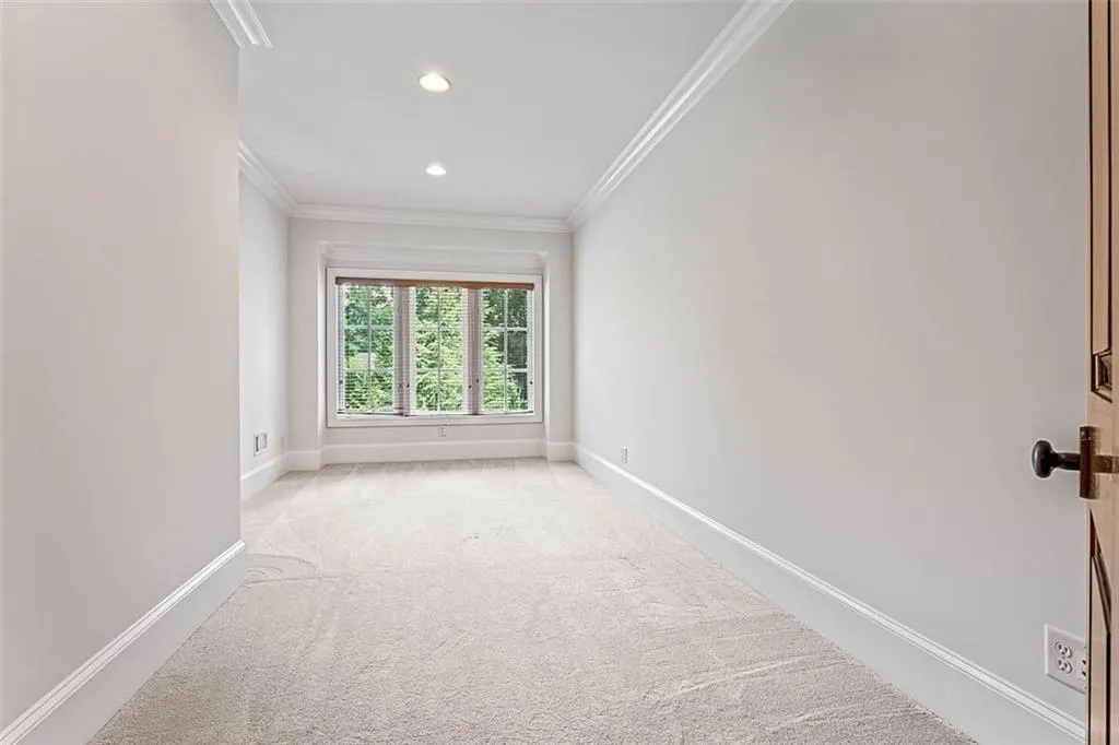 Carpeted empty room featuring crown molding