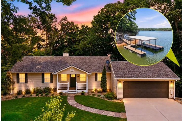 Home exterior featuring a covered front porch, attached two-car garage, and a manicured lawn