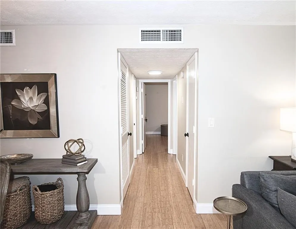 Hall with light wood-style floors and a textured ceiling