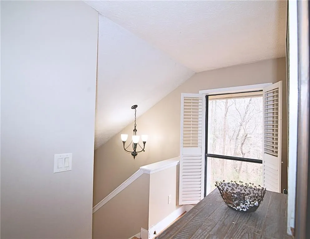 Hall with an upstairs landing and a chandelier