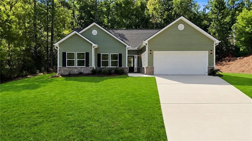 Ranch-style exterior with green siding and stone accents