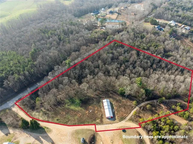 Aerial view of property and surrounding area with property parcel outlined and a nearby body of water