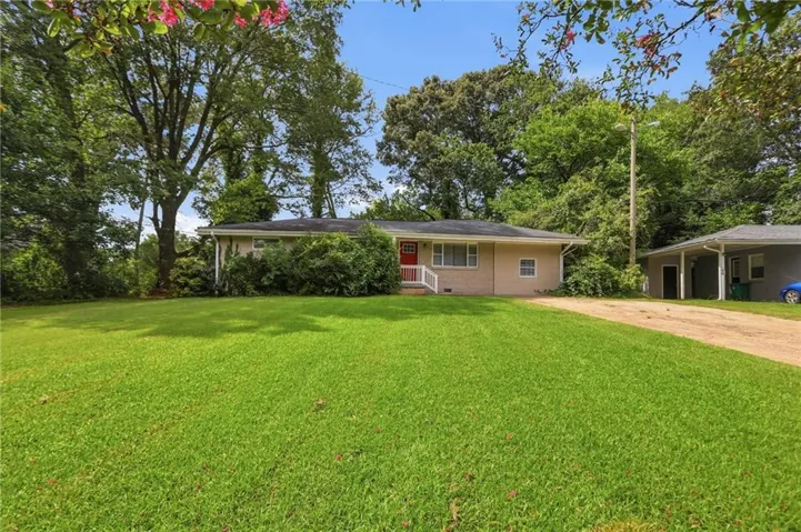 Ranch-style exterior with a red front door, white railing, and a broad front lawn