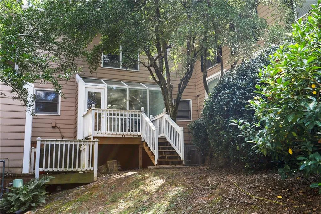 Rear view of house featuring a wooden deck and stairs