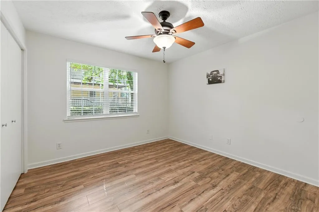 Spare room featuring a textured ceiling, wood finished floors, and a ceiling fan