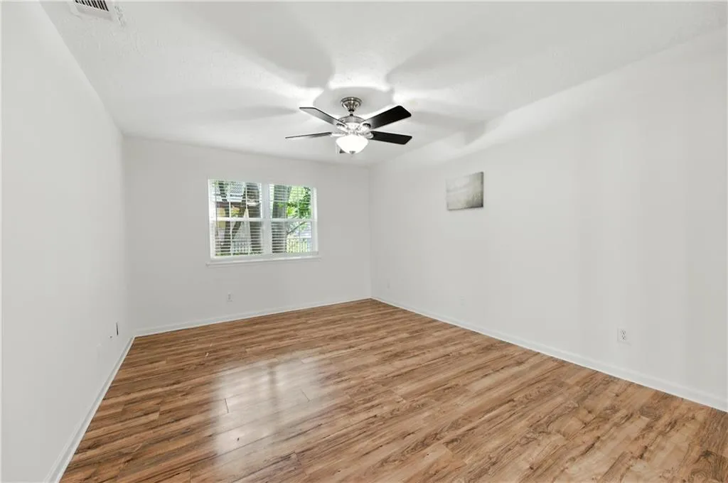 Spare room with wood finished floors and ceiling fan