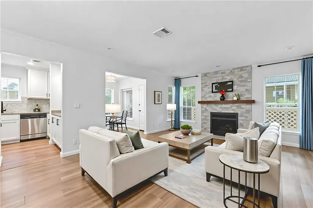 Living room featuring a stone fireplace and light wood-style floors