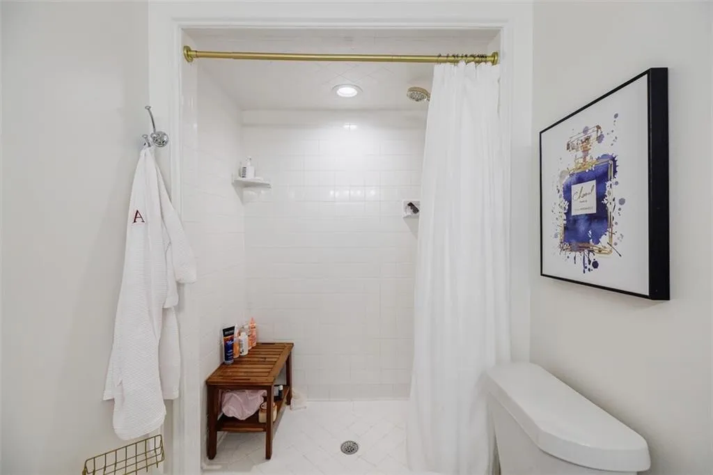 Bathroom featuring a tile shower and toilet