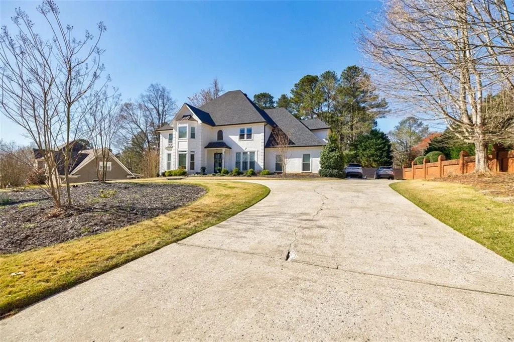 View of front of house featuring fence, concrete driveway, and a front yard