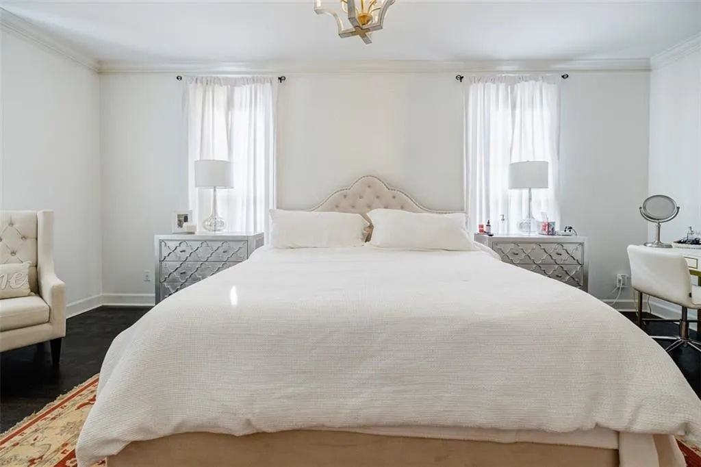 Bedroom with ornamental molding, dark wood-style floors, baseboards, and a chandelier
