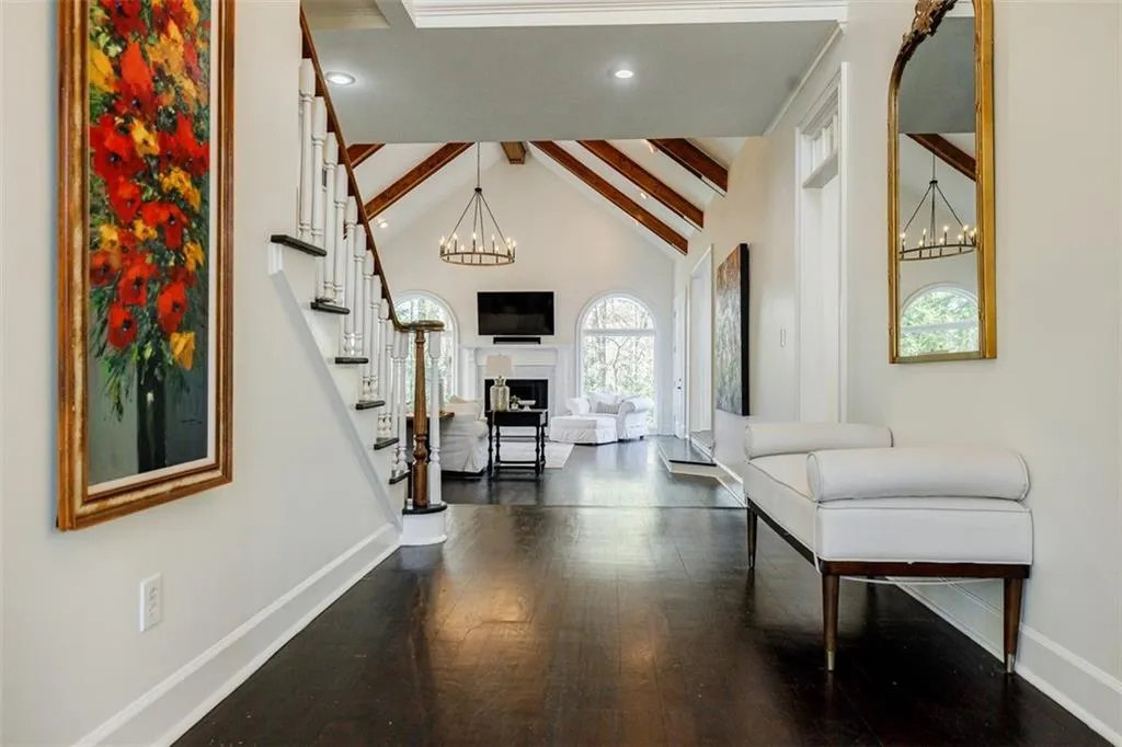 Foyer entrance with dark wood-type flooring, beamed ceiling, stairs, and baseboards
