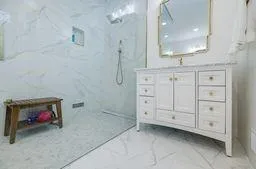 Bathroom featuring marble finish floor, vanity, and a marble finish shower