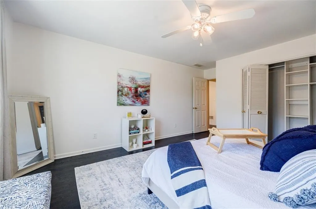 Bedroom featuring baseboards, dark wood finished floors, visible vents, a closet, and ceiling fan