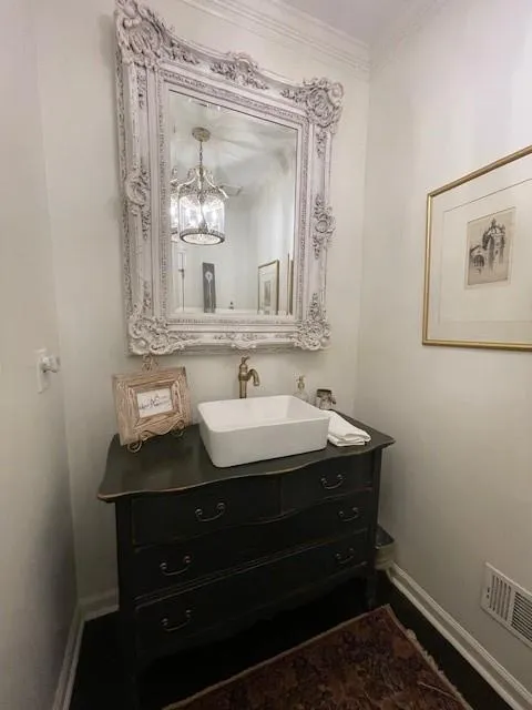 2nd Powder Room on Main with vanity, a chandelier, baseboards, visible vents, and ornamental molding