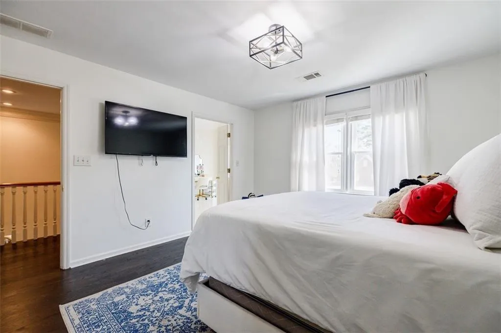 Bedroom with baseboards, visible vents, and dark wood-type flooring
