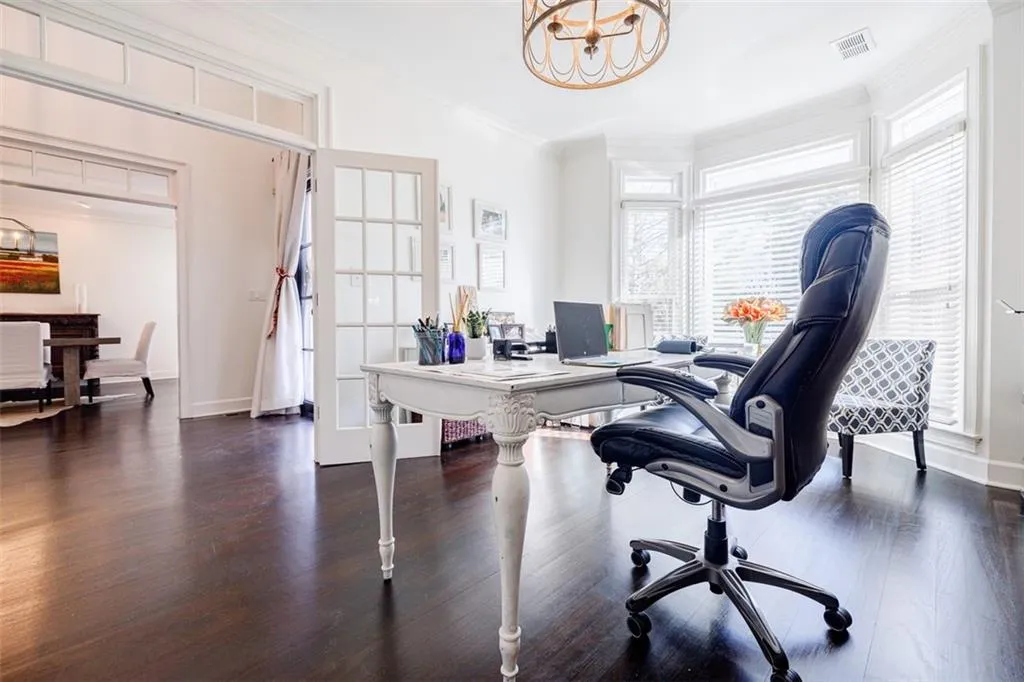 Office with crown molding, baseboards, a chandelier, visible vents, and wood finished floors