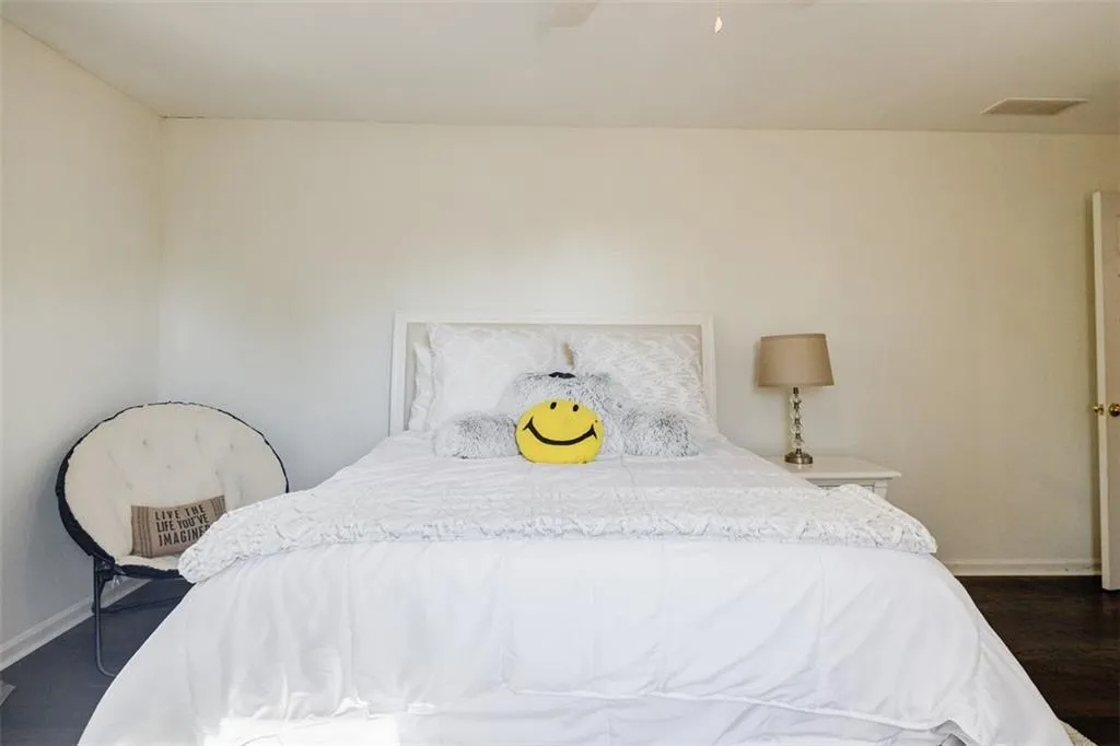 Bedroom with baseboards, visible vents, and dark wood-style flooring
