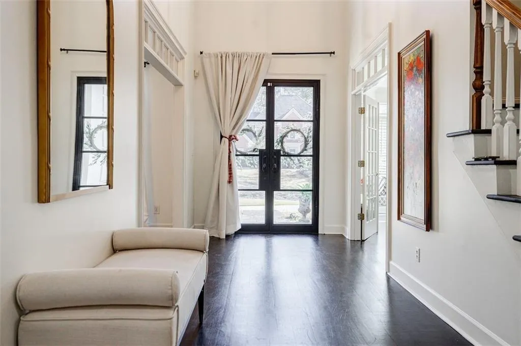Foyer entrance with french doors, baseboards, and dark wood finished floors