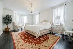 Bedroom featuring dark wood-style floors and multiple windows