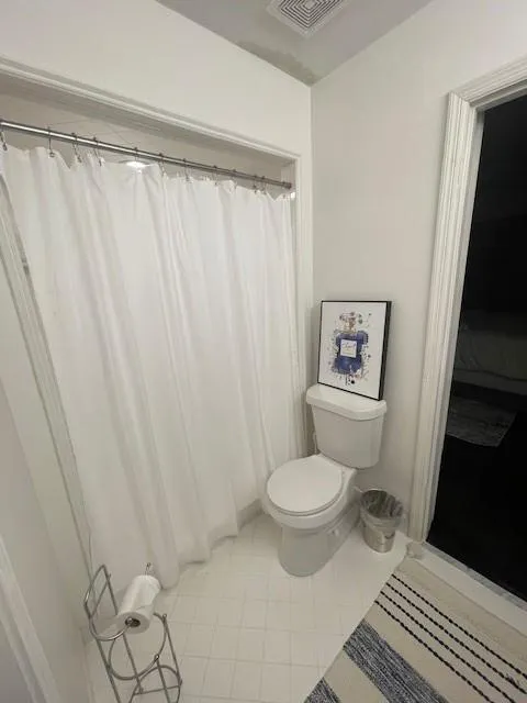 3rd Full bath with visible vents, toilet, and tile patterned flooring