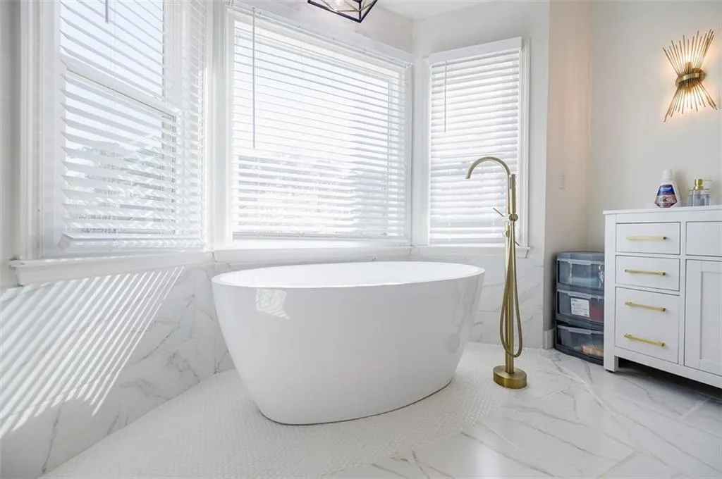 Bathroom featuring marble finish floor and a freestanding bath