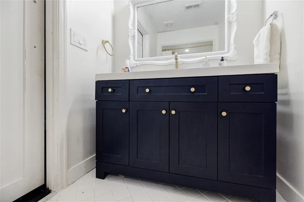 Bathroom featuring vanity, baseboards, and visible vents