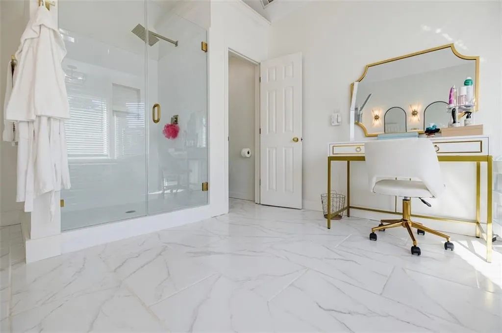 Full bath with marble finish floor and a shower stall