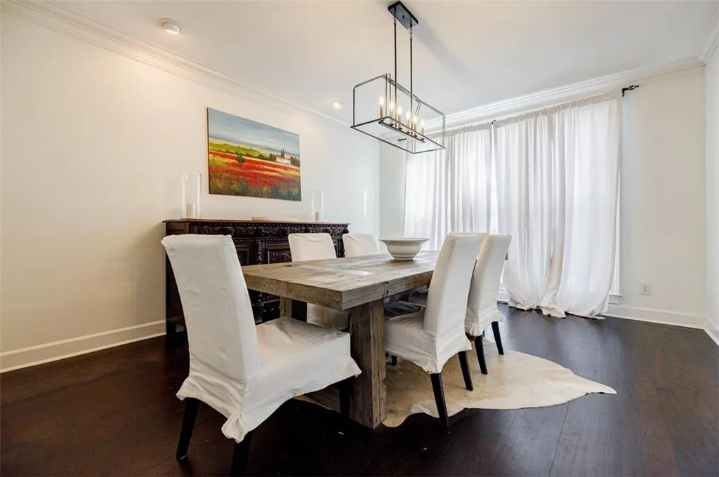 Dining area featuring baseboards, ornamental molding, and dark wood-type flooring