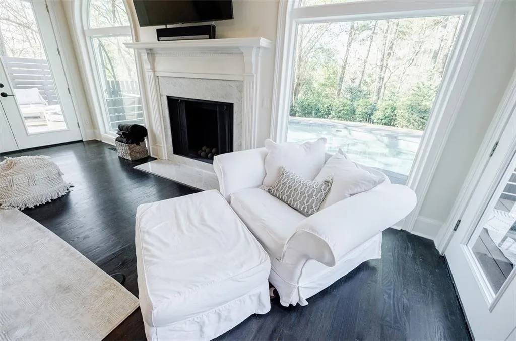 Living area featuring baseboards, wood finished floors, and a high end fireplace