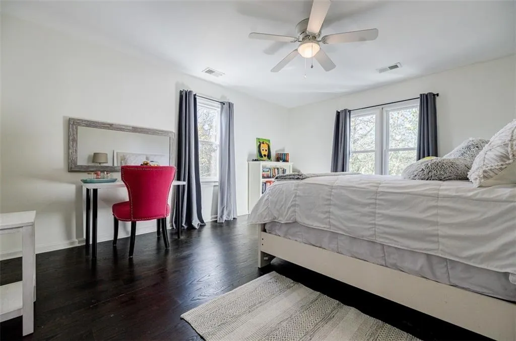 Bedroom with visible vents, multiple windows, and wood finished floors