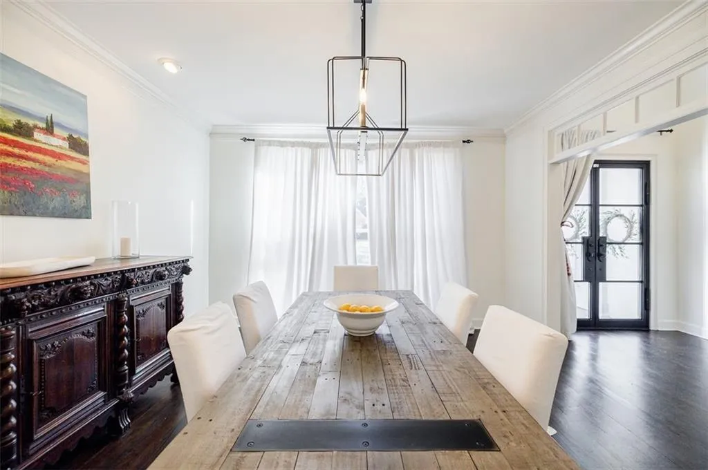 Dining area with ornamental molding, wood finished floors, and french doors