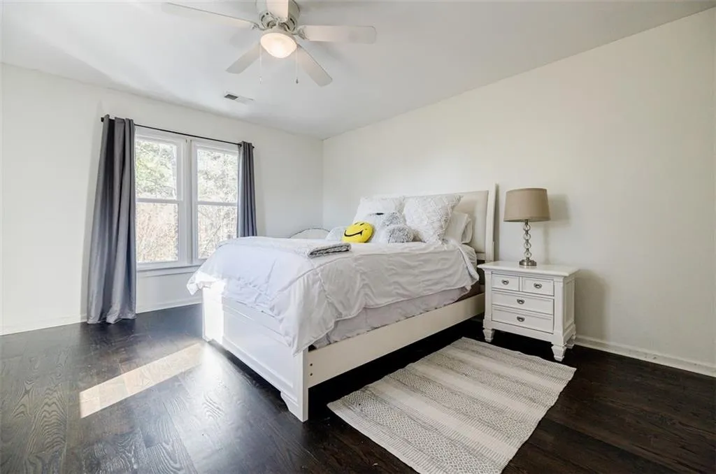 Bedroom with baseboards, visible vents, and dark wood finished floors