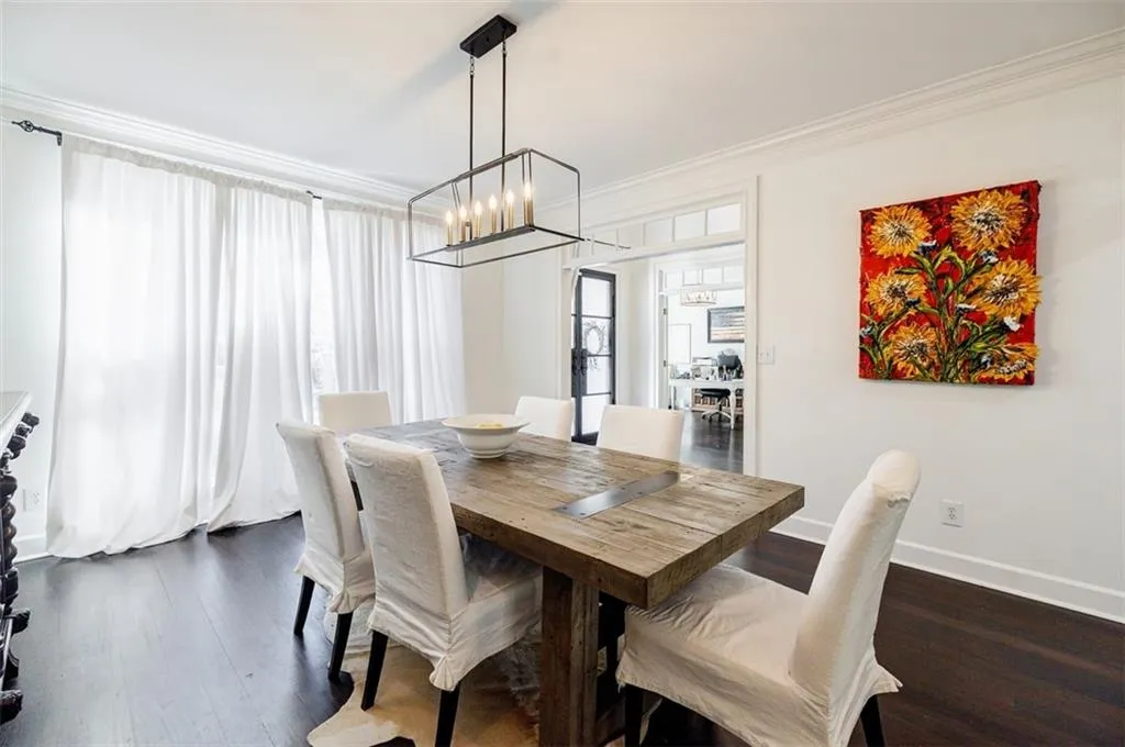 Dining area featuring baseboards, a notable chandelier, crown molding, and dark wood-type flooring