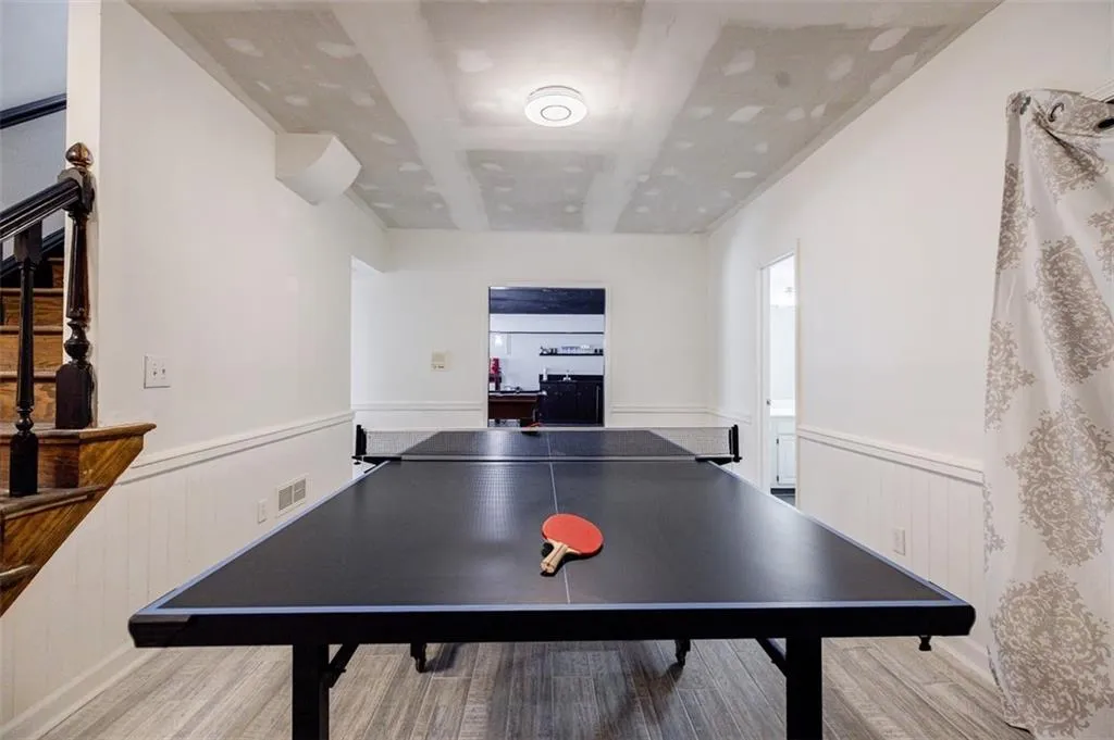 Playroom featuring wainscoting, visible vents, and wood finished floors