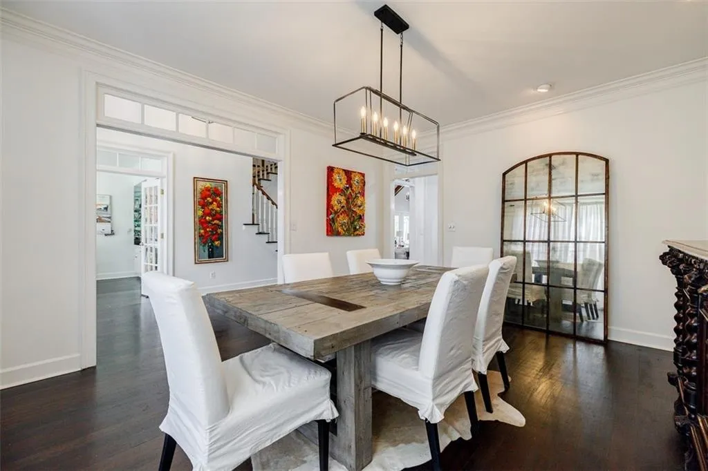 Dining space featuring stairs, a chandelier, dark wood finished floors, baseboards, and ornamental molding