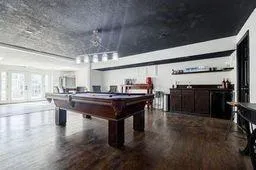 Recreation room with wood finished floors and billiards