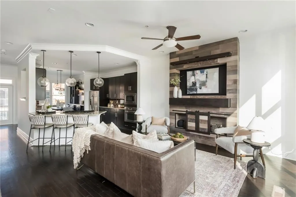 Open concept main level with floating staircase and grand kitchen with stainless steel appliances and hardwood floors