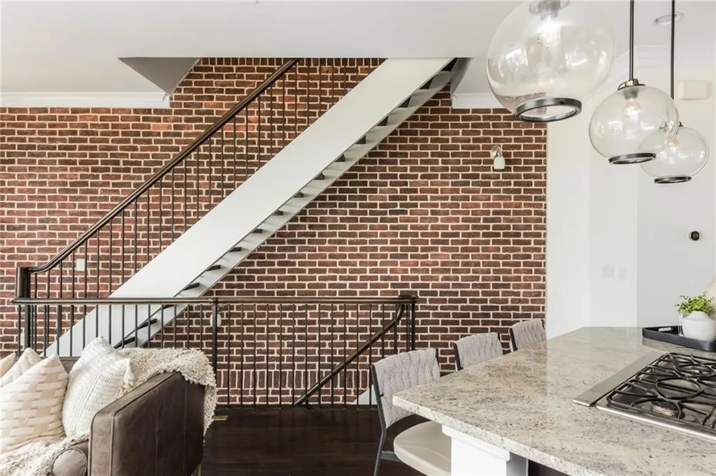 Brick accent wall and floating staircase add character throughout the home