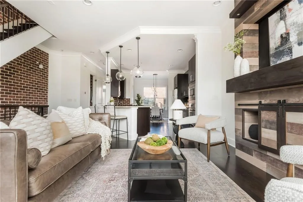 Open concept main level with floating staircase and grand kitchen with stainless steel appliances and hardwood floors