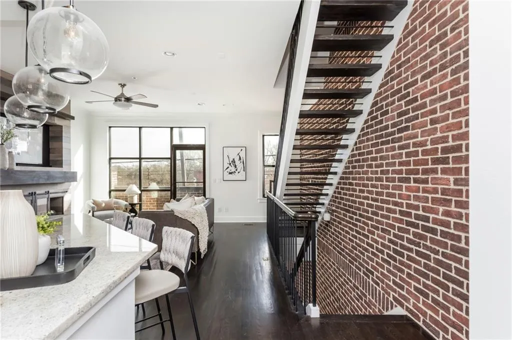 Brick accent wall and floating staircase add character throughout the home