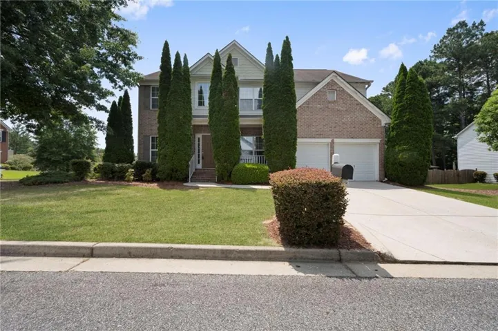Two-story residence featuring brick and siding facade, an attached two-car garage, and a concrete driveway